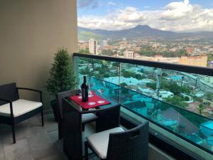 einen Balkon mit einem Tisch und Stühlen sowie Stadtblick in der Unterkunft JF Three Bedroom Apartment in Tegucigalpa