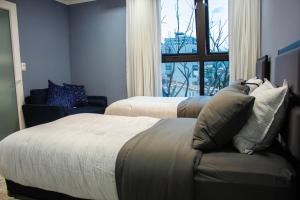 特古西加尔巴JF Three Bedroom Apartment的一间卧室设有两张床、一张沙发和一个窗口