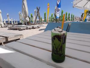 a drink sitting on a table next to a pool at Vila LaDom Etajul 1 in Mamaia Sat/Năvodari