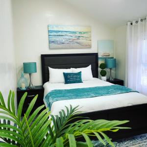 a bedroom with a bed with blue lamps and plants at Water Canal Villa Salgado in Bellmore