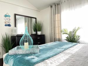 a bedroom with a bed with a blue blanket and a mirror at Water Canal Villa Salgado in Bellmore