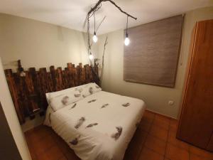 a bedroom with a bed with a wooden headboard at LA LEYENDA DEL CURAVACAS in Alba de los Cardaños