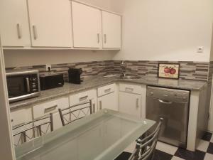 a kitchen with white cabinets and a counter top at AL Colmeia de Mel in Reguengos de Monsaraz