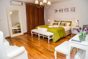 a bedroom with a large bed with a green blanket at Sorrento Hotel Boutique in Trenque Lauquen +49 photos