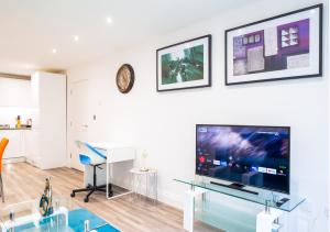 a living room with a large television and a table at The 'Pinky' - Beautiful 1 Bed Apartment in Hatfield - FREE Parking - Near Uni & Business Park - Long stays - Corporate, Leisure, Contractors in Hatfield
