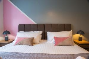 um quarto com uma cama grande com lençóis brancos e almofadas em The 'Pinky' - Beautiful 1 Bed Apartment in Hatfield - FREE Parking - Near Uni & Business Park - Long stays - Corporate, Leisure, Contractors em Hatfield