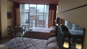 een slaapkamer met 2 bedden en een groot raam bij Hotel Paraíso in Callampaya