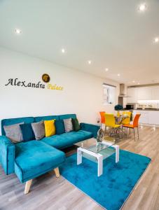 ein Wohnzimmer mit einem blauen Sofa und einem Tisch in der Unterkunft The 'Pinky' - Beautiful 1 Bed Apartment in Hatfield - FREE Parking - Near Uni & Business Park - Long stays - Corporate, Leisure, Contractors in Hatfield