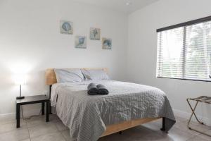 ein Schlafzimmer mit einem Bett mit zwei Paar Schuhen darauf in der Unterkunft New house on the block near Miami Airport. in Miami