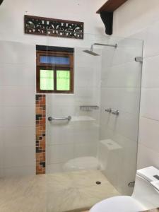Un baño con ducha de cristal con inodoro. en Refugio Villa Tere, en Villa de Leyva