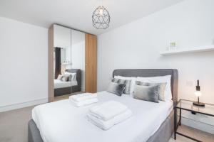 una camera da letto con un grande letto bianco con asciugamani di The Upper House - Fitzrovia - by Frankie Says a Londra