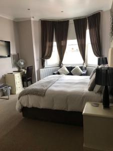 Un dormitorio con una cama grande y una ventana en Ashmira Guest House, en Weymouth