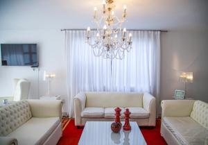 a living room with two white couches and a chandelier at Sorrento Hotel Boutique in Trenque Lauquen
