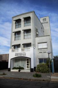 een hoog wit gebouw met een bord erop bij Sorrento Hotel Boutique in Trenque Lauquen