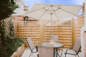 a patio with a table and an umbrella at 1 Chantry Cottage in Tunstall
