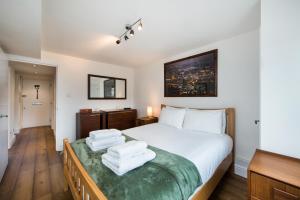 um quarto com uma cama grande e toalhas em Views For Days - Fitzrovia - by Frankie Says em Londres