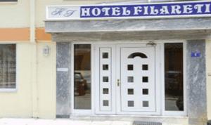 a hotel with a sign on the front of a building at Filareti Hotel in Florina