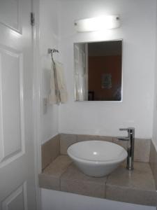 y baño con lavabo blanco y espejo. en Hotel Santa Cruz, en Chihuahua