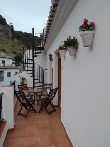 balkon ze stołem, krzesłami i schodami w obiekcie Apartamento en Frigiliana w mieście Frigiliana +6 zdjęć
