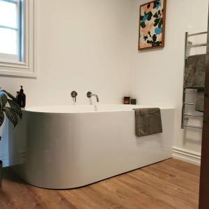 a bath tub in a room with a sink at Mill House in Pohokura