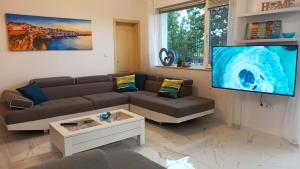 a living room with a couch and a flat screen tv at Arode Villa Ovidius in Balchik