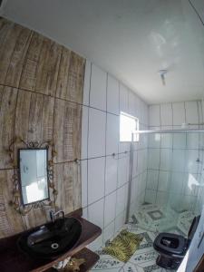 baño con lavabo y espejo en la pared en Casa Da Cléo Carrancas, en Carrancas