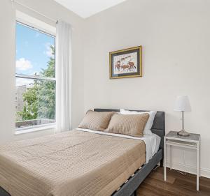 a white bedroom with a bed and a window at Spacious 5-BR Apt next to transit Free Parking in Chicago