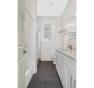 a white bathroom with a tub and a toilet and a sink at Spacious 5-BR Apt next to transit Free Parking in Chicago +15 photos