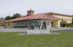 una estatua de tres personas frente a un edificio en Björkbackens Karaktärshotell, en Vimmerby