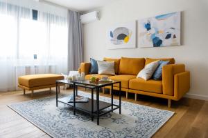 uma sala de estar com um sofá e uma mesa em Akiton Apartment em Belgrado