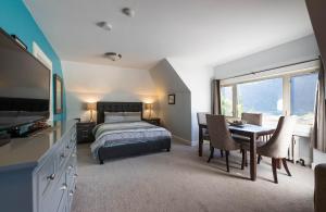 a bedroom with a bed and a table and chairs at Cloudside Hotel in Nelson