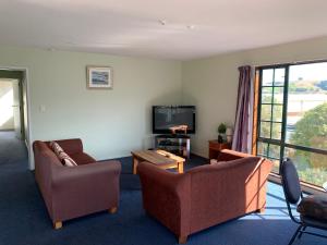 a living room with two couches and a tv at 3 Bedroom Apartment, Kaikoura in Kaikoura