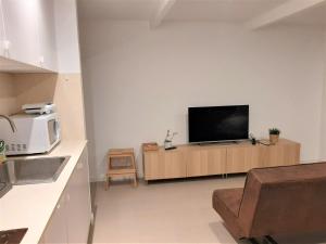 a living room with a flat screen tv on a wall at Casa das Camélias Garden Guesthouse in Aveiro