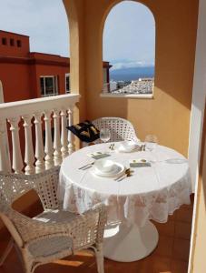 una mesa y sillas blancas con una mesa blanca y una ventana en Ocean View Suite Close to Beach with Pool & WiFi, en Callao Salvaje