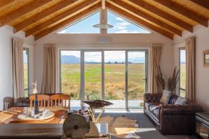 a living room with a couch and a large window at The Lodge, with Mt Cook views in Twizel