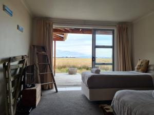 a bedroom with two beds and a window with a view at The Lodge, with Mt Cook views in Twizel