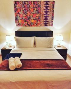 una camera da letto con un grande letto con due asciugamani di FAMISA Eastern Gold Service Apartment a Kertih