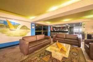 una sala de estar con 2 sofás marrones y una mesa. en Happy 313 apartamento Frente mar, en Natal