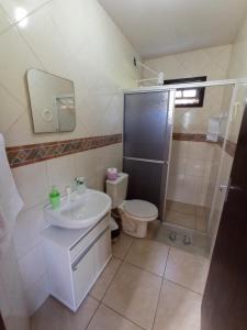 y baño con lavabo, aseo y ducha. en Pousada Biso Finoca Ibiraquera, en Imbituba