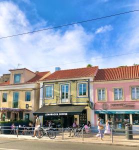 a group of people walking down a street in front of buildings at Frank's House & Happy BELEM in Lisbon