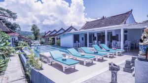 a group of chairs sitting next to a swimming pool at Salt Resort & Spa in Amed