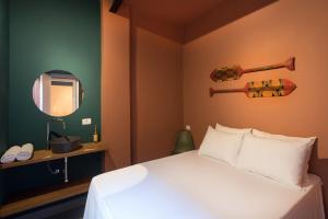 ein Hotelzimmer mit einem Bett und einem Spiegel in der Unterkunft Ô de Casa Hostel in São Paulo