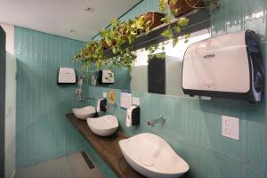 a bathroom with two toilets on a blue tiled wall at Ô de Casa Hostel Bar in São Paulo