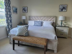 a bedroom with a bed with a bench and two lamps at Our Naples Hideaway in Naples