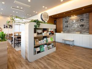 a library with a book shelf in the middle of a room at Comfort Hotel Toyama in Toyama