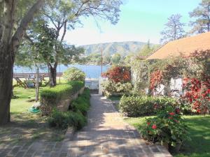 a path in a park next to a body of water at Aguada Chica Bungalows in Villa Carlos Paz