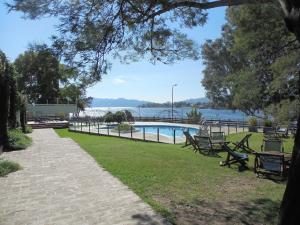 a park with benches and a view of the water at Aguada Chica Bungalows in Villa Carlos Paz