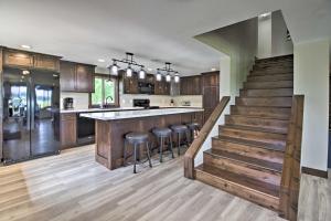 una cocina con armarios de madera y un bar con taburetes en Platte Lake Home with Boat Launch and Deck! en Vineland