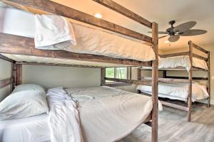 VinelandPlatte Lake Home with Boat Launch and Deck!的带吊扇的客房内的两张双层床