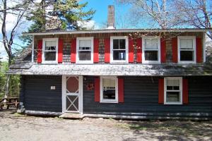 an old house with red and black paint on it at Robinson's Cottages in Township of Edmunds